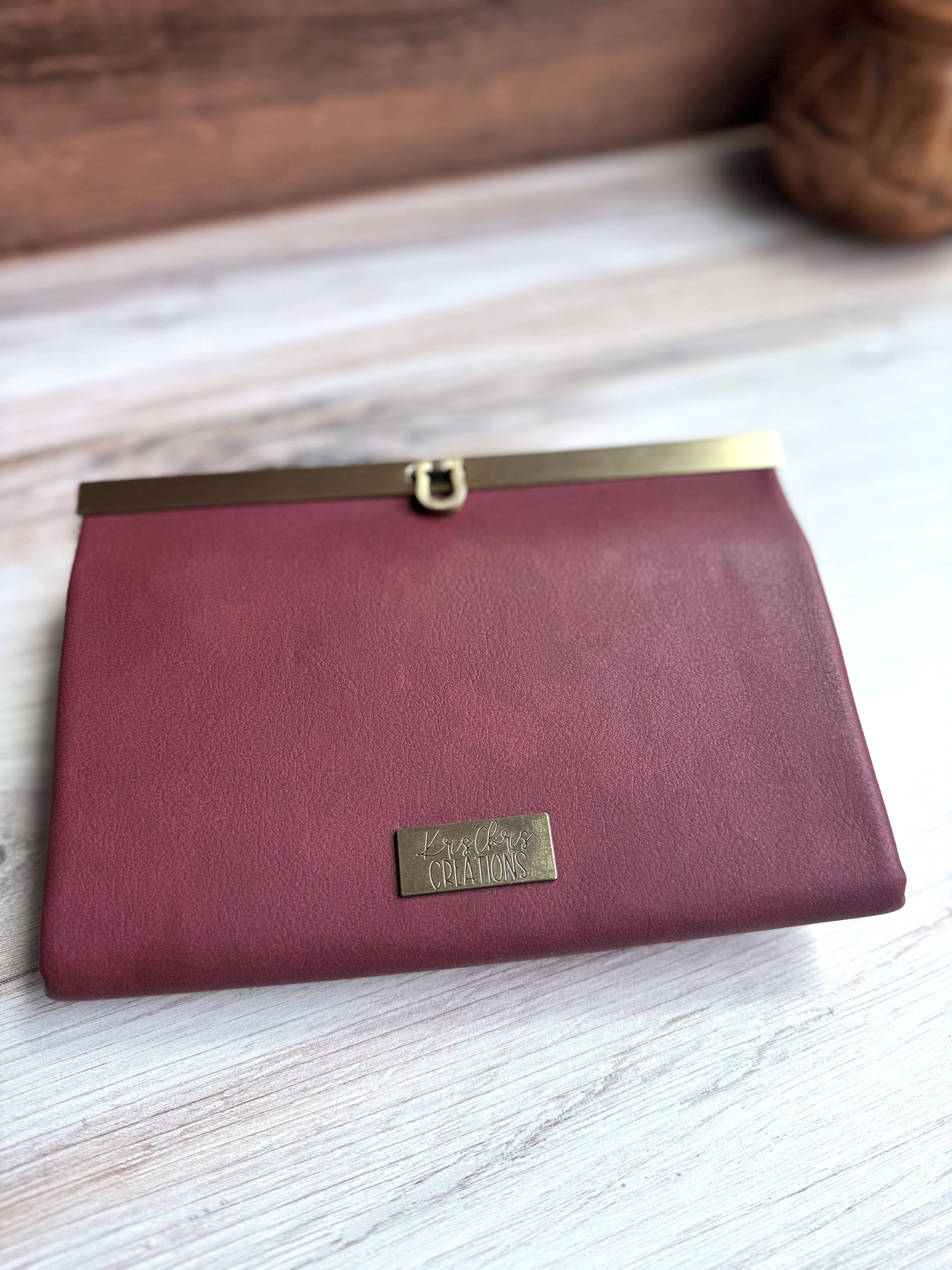 Red Wine Vinyl (vegan leather) accordion wallet, closed with antique brass hardware along top edge. Folds in compact rectangle.