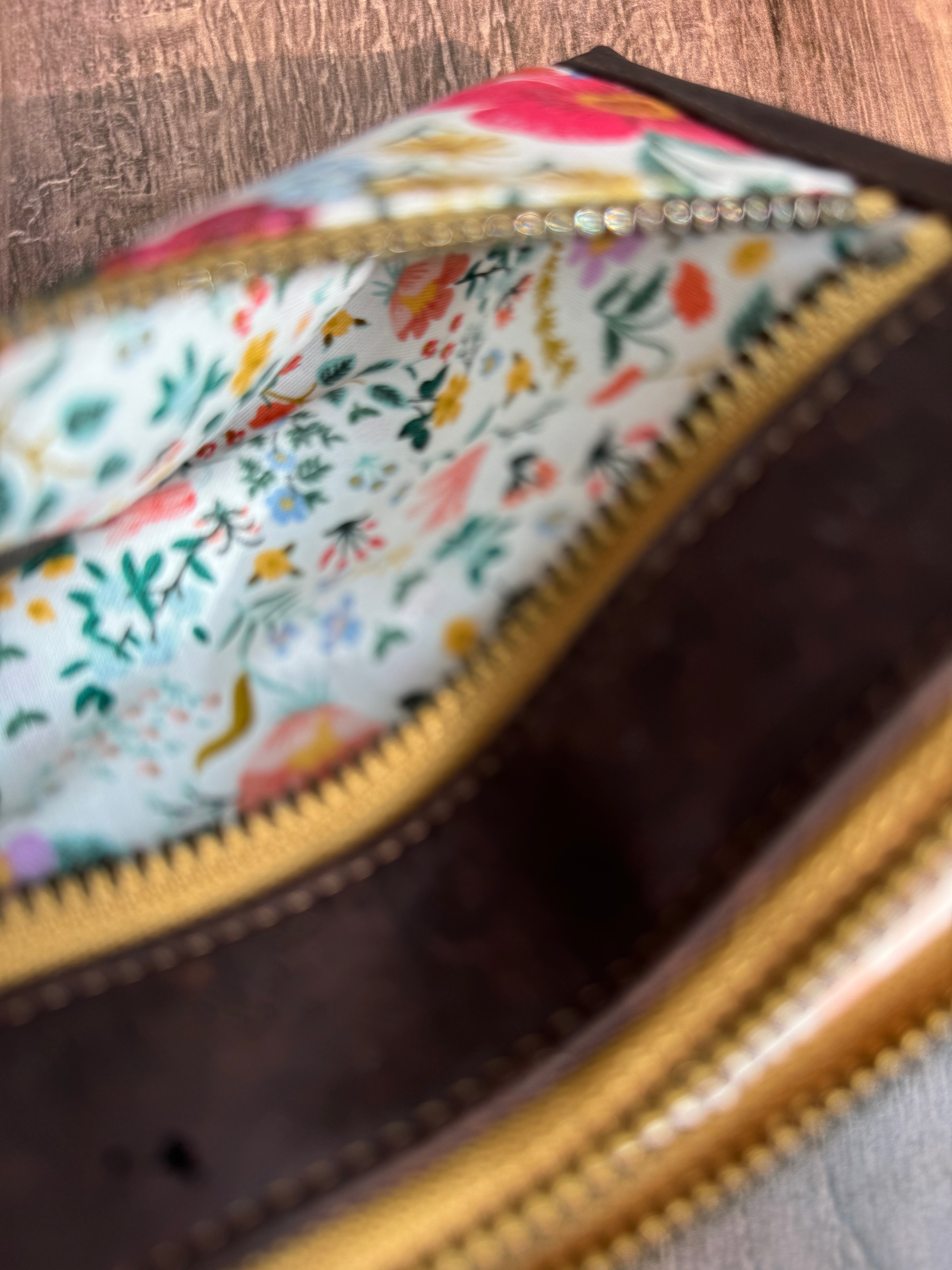 Small zipper is open to show more small floral print with white background and dainty flowers of all colors.