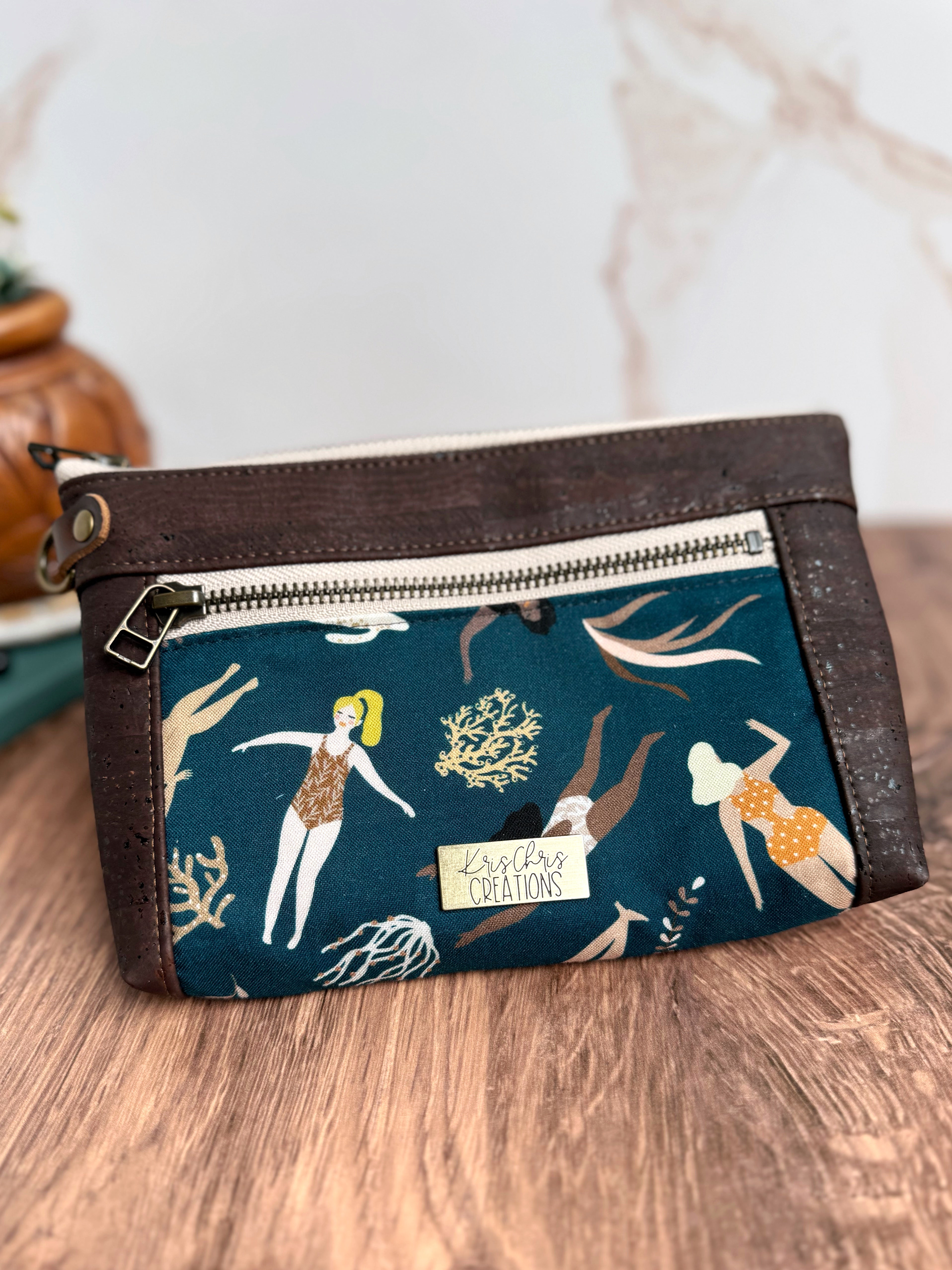 Chocolate brown cork trim pouch with dark teal fabric featuring ladies in bathing suits swimming