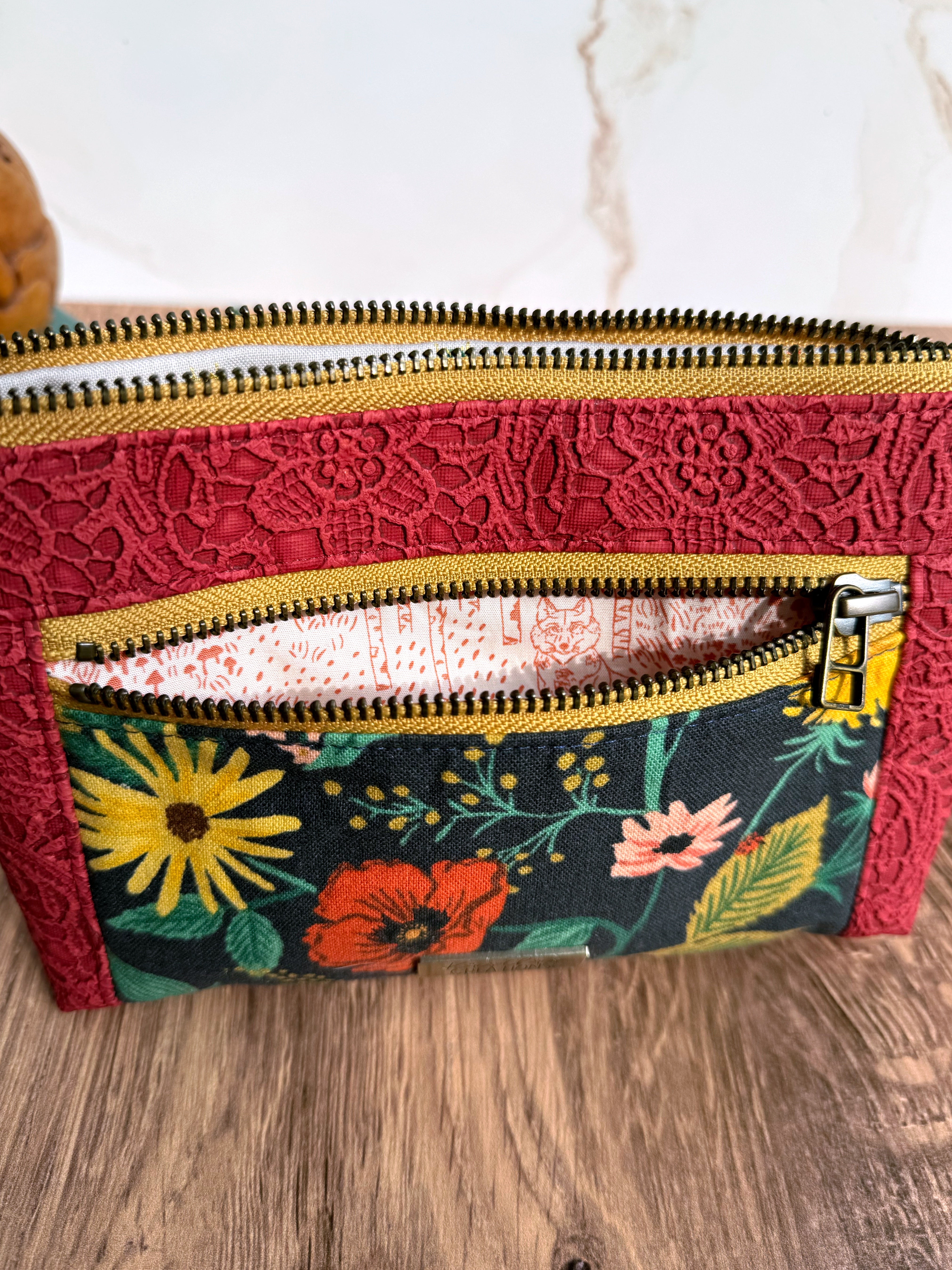 Open small zipper pocket shows illustrated fabric inside showing mushrooms, trees, and a foxes.