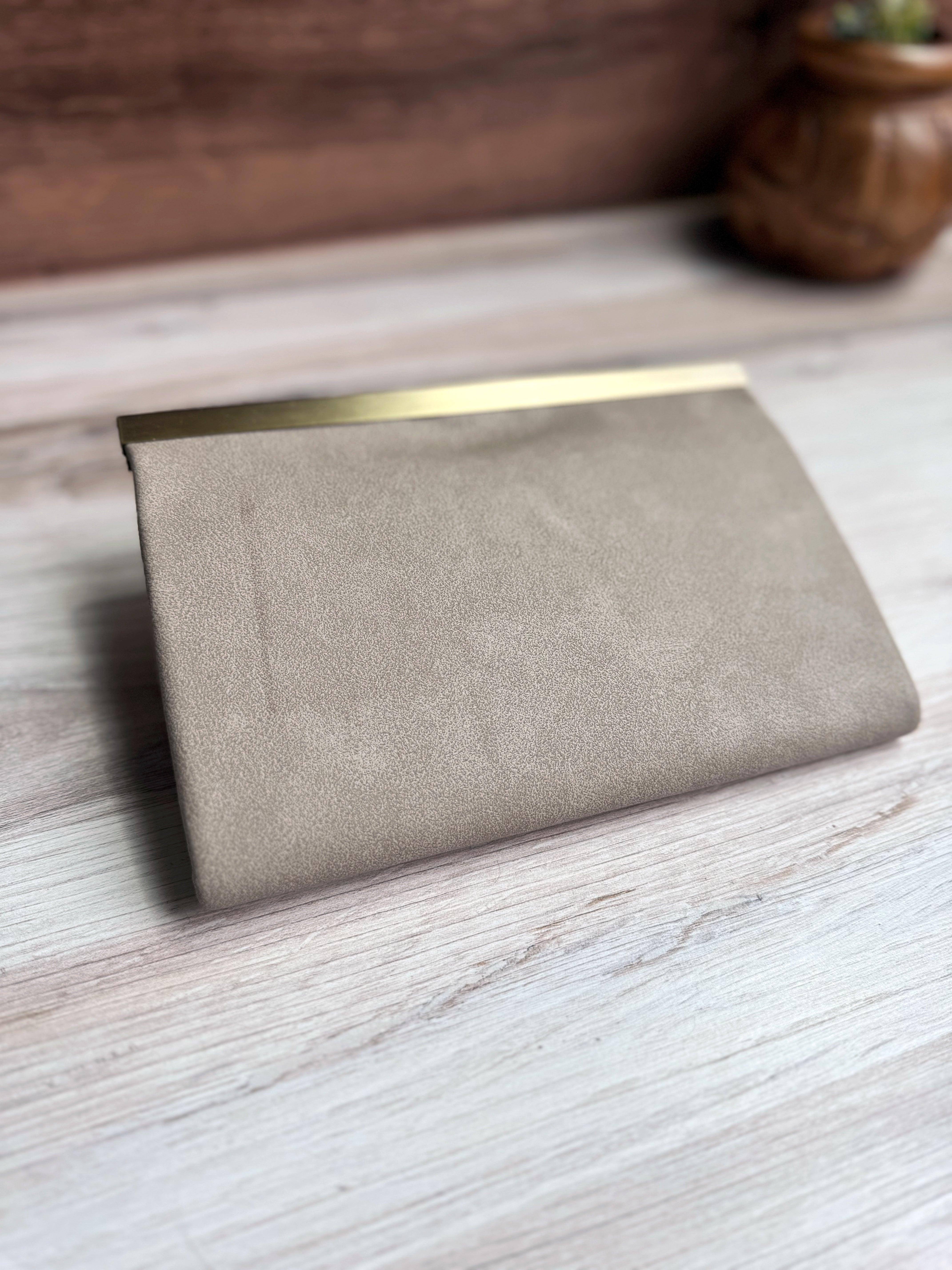 Back side of Gray/Tan accordion style wallet with a sleek exterior, antique brass metal clasp at top.