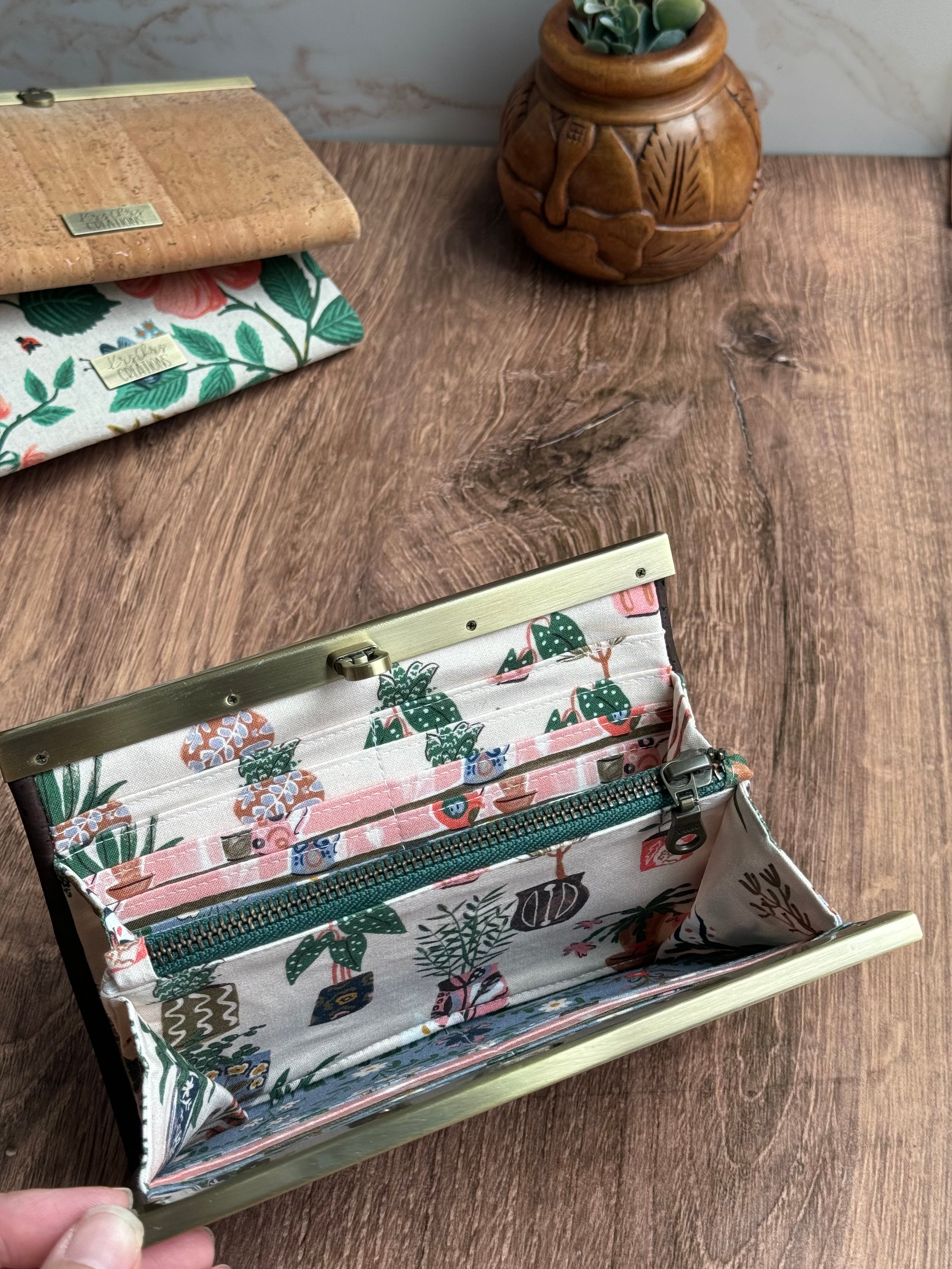 Open accordion wallet with green zipper and many card slots, fabric features house plants of all kinds