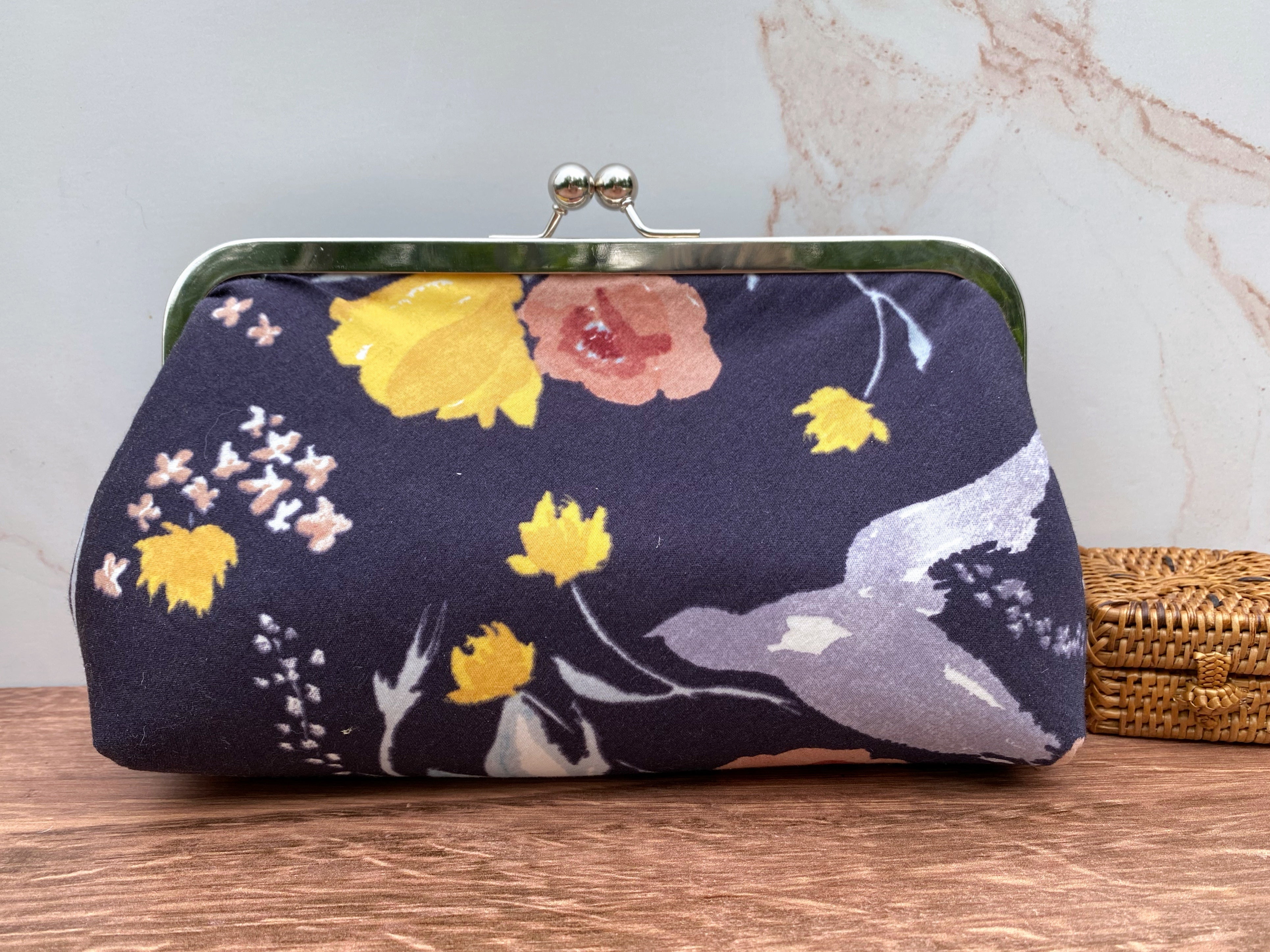 Floral Navy Twist lock clutch with silver hardware. Fabric is whimsical and looks like a watercolor painting.