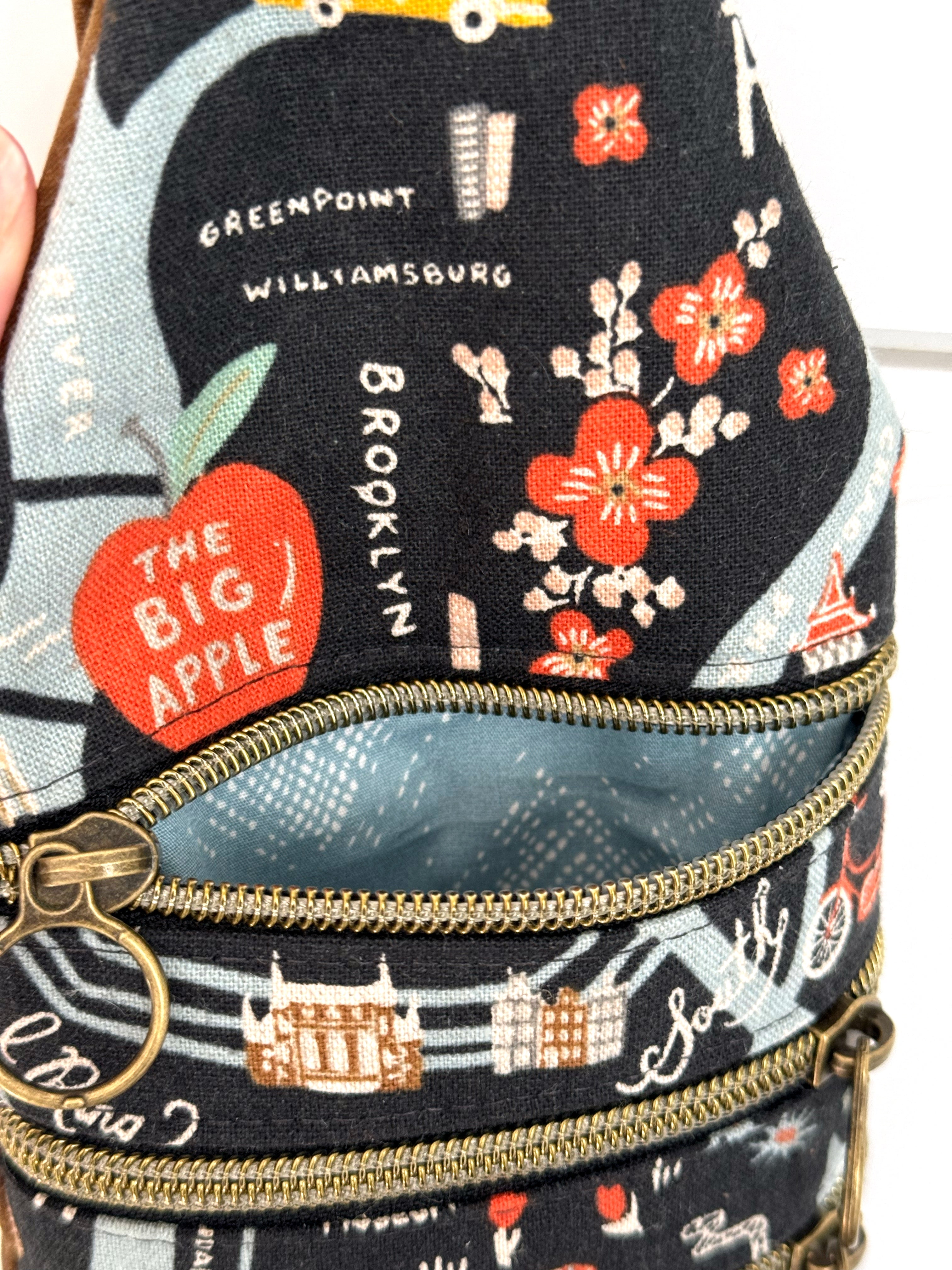 Bag with illustrated New York City map with opened zipper with light blue fabric lining