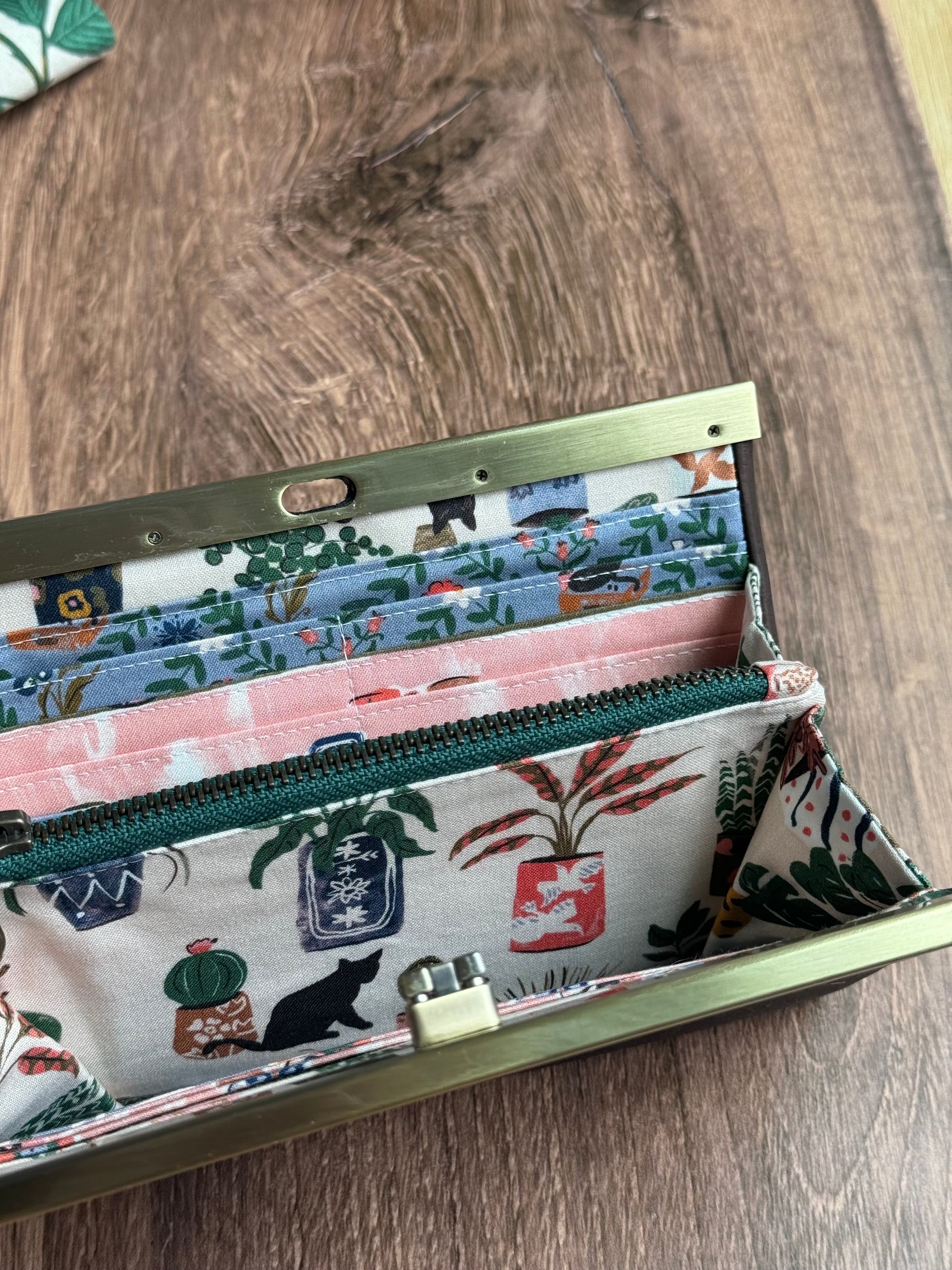Open accordion wallet with green interior zipper, pink and blue illustrated fabrics with many card slots.