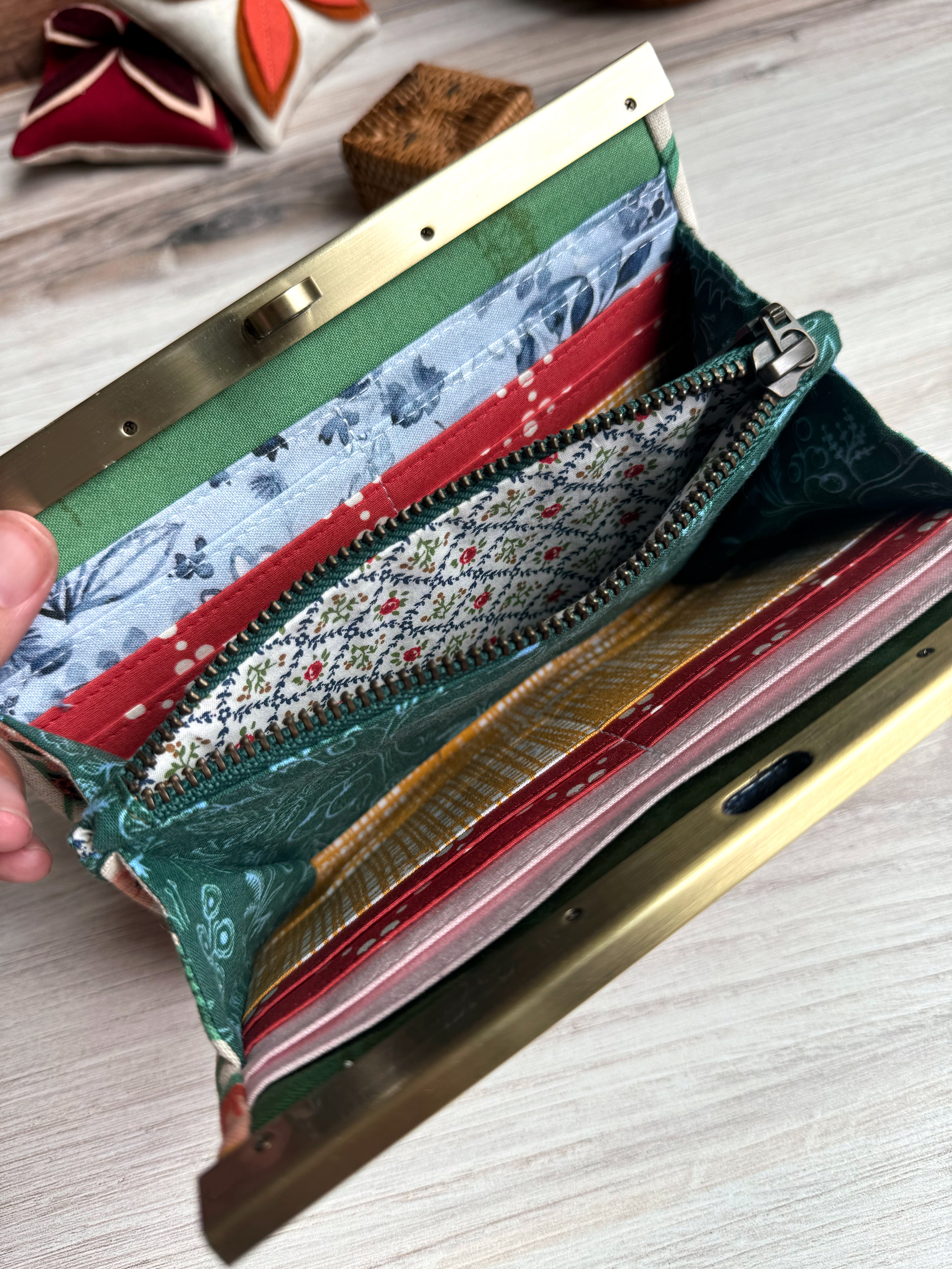 Interior of accordion wallet with open interior zipper revealing blue white and red floral fabrics. Many card slots.