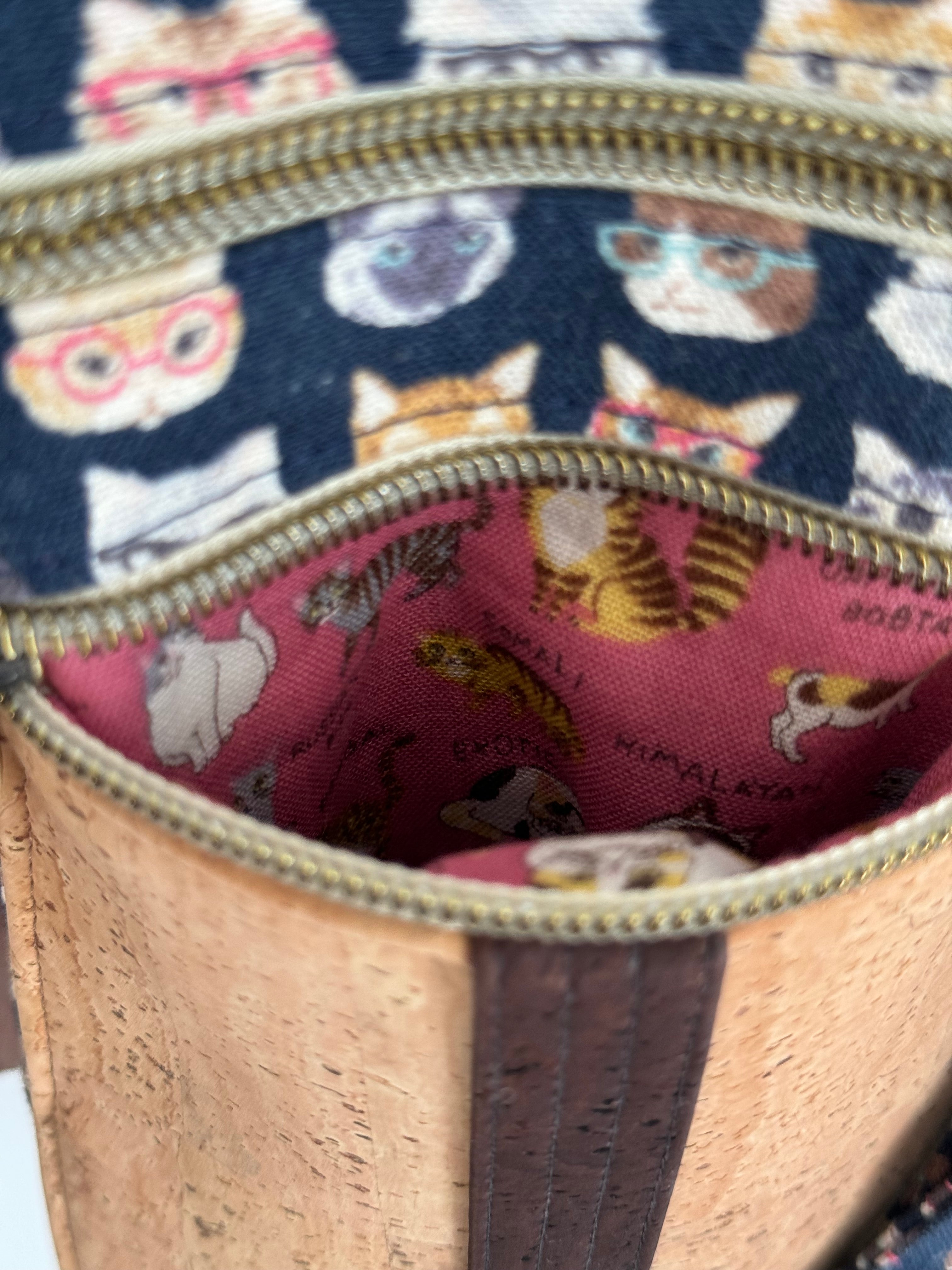 Inside view of open zipper of cat bag with pink fabric with different cat breeds