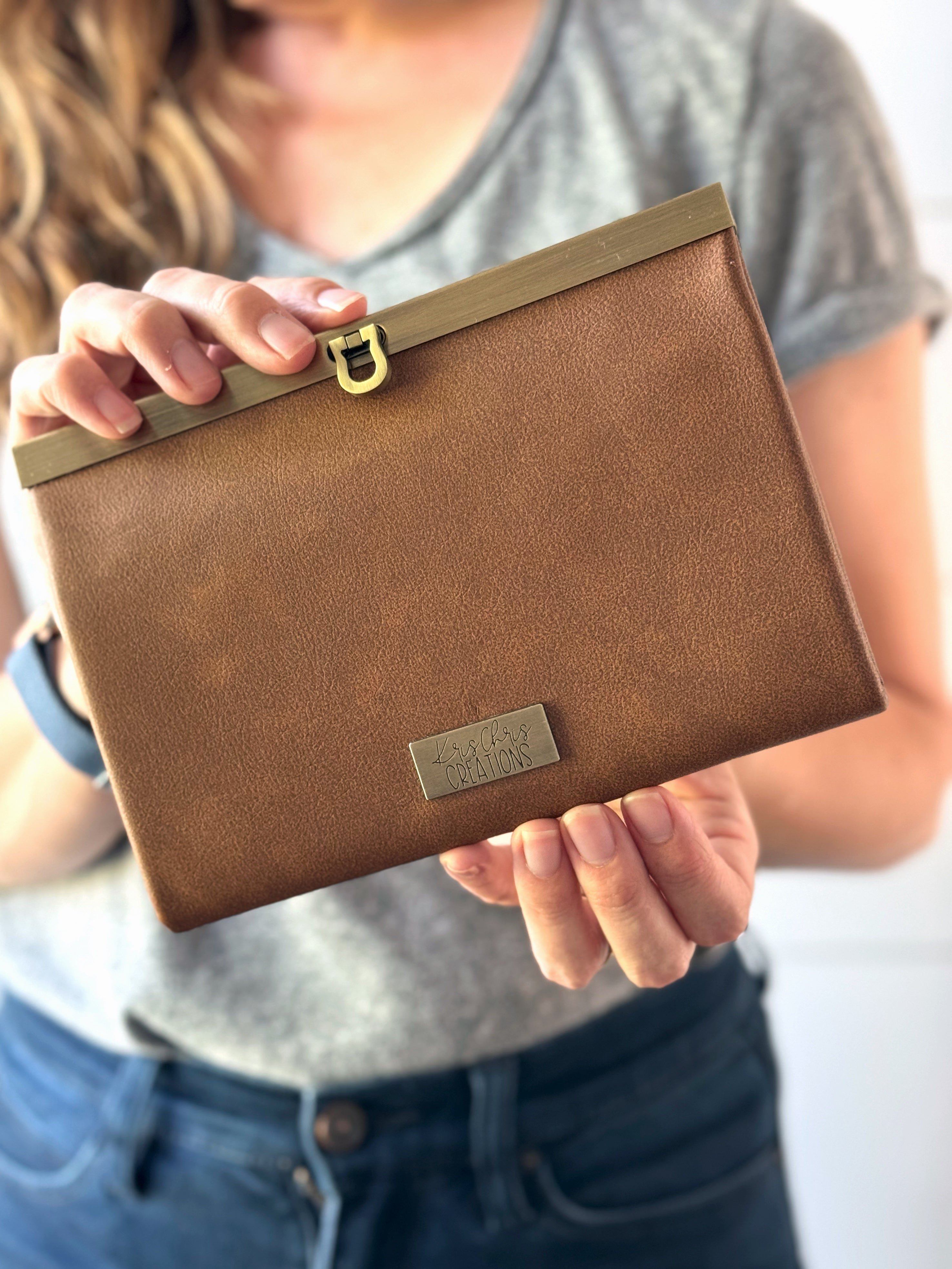 Tan Vinyl (vegan leather) accordion wallet, closed with antique brass hardware along top edge. Folds in compact rectangle.