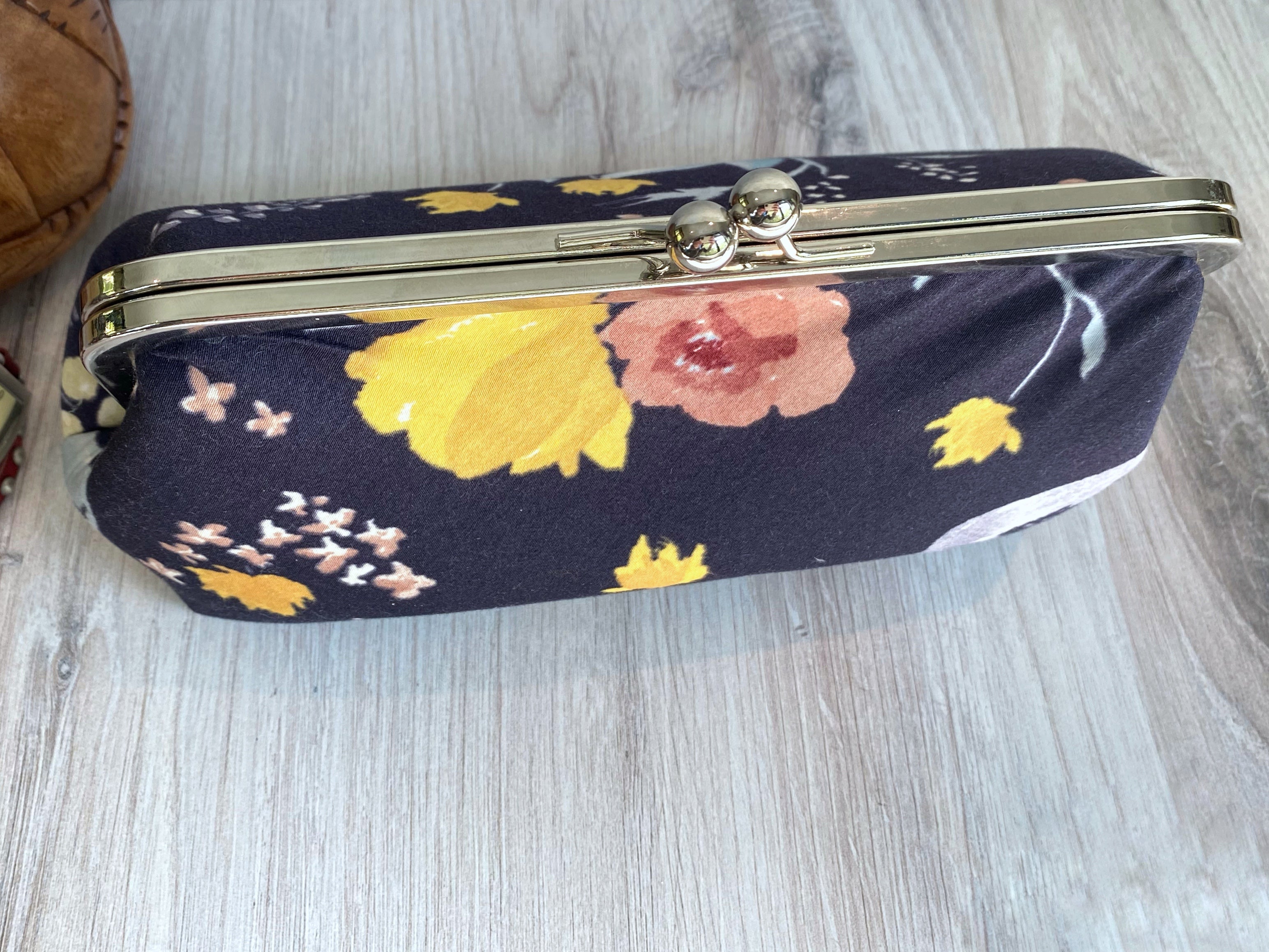 Top view of kisslock clutch in silver hardware and floral navy Japanese fabrics