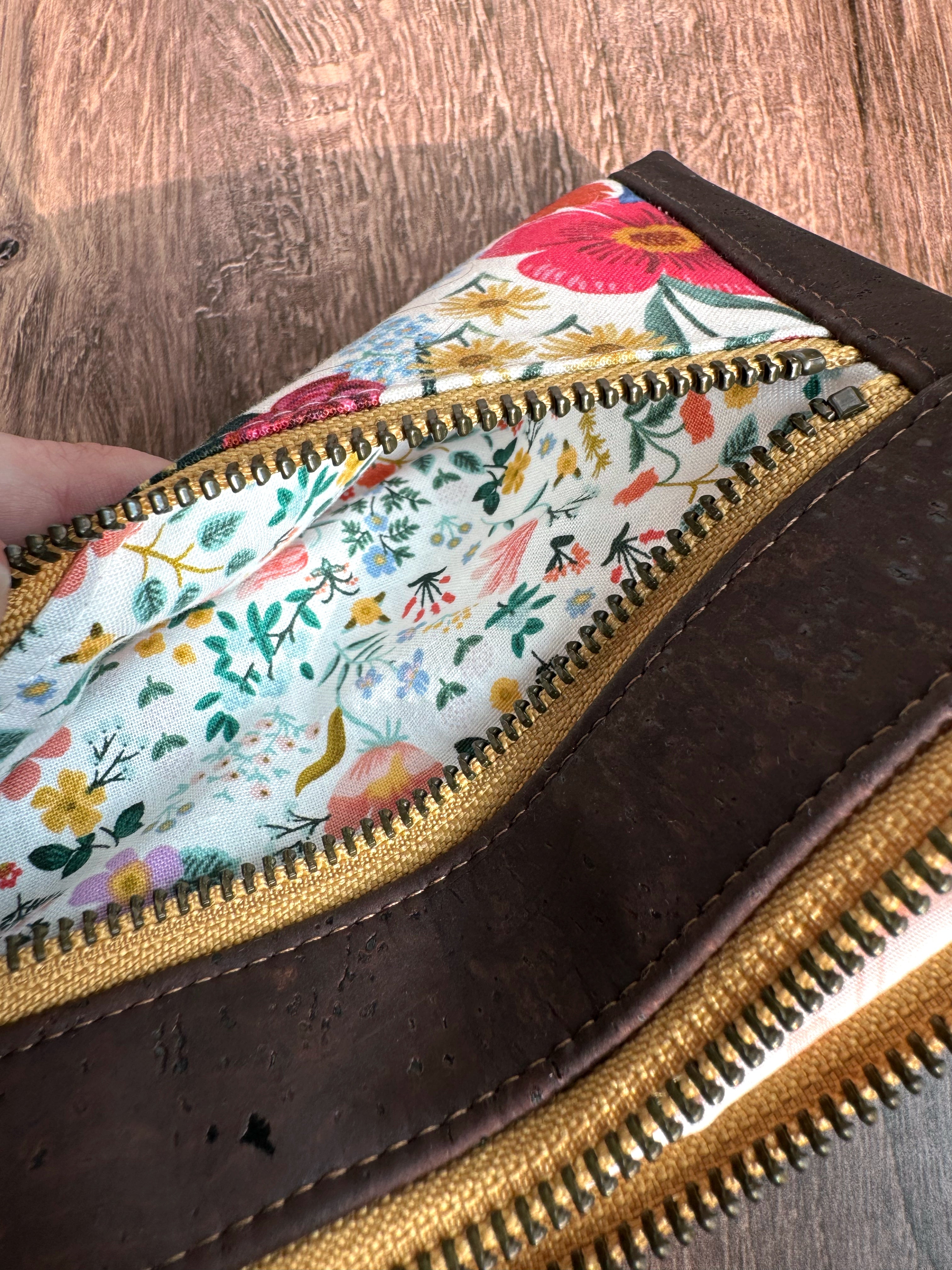 Small zipper is open to show more small floral print with white background and dainty flowers of all colors.
