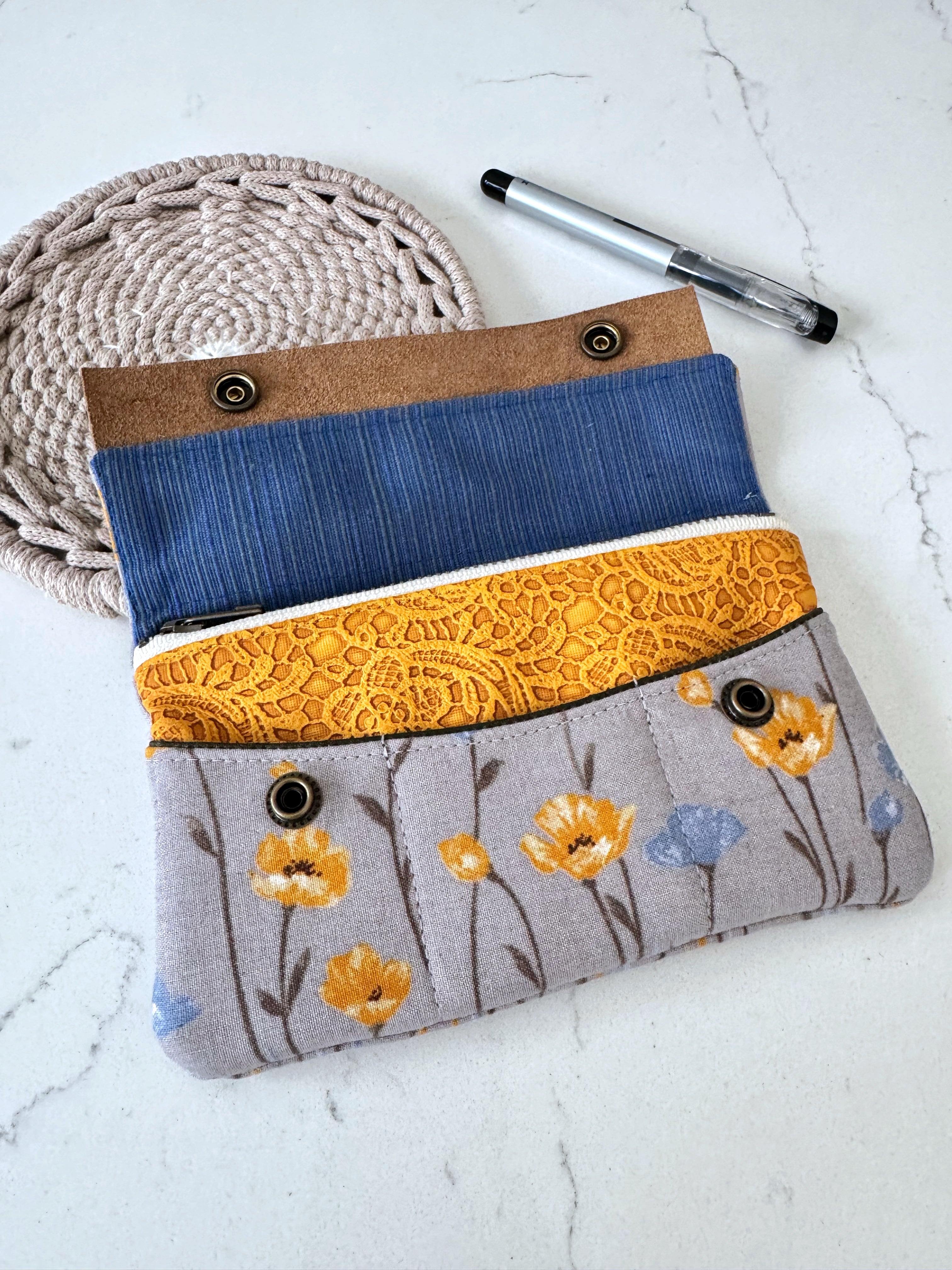 Fabric pouch with blue and yellow sections on a white surface