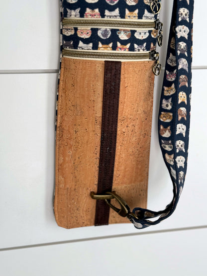 A strip of chocolate brown cork fabric detail over the light cork fabric shows brass hardware that allow the bag to be adjusted and customized.