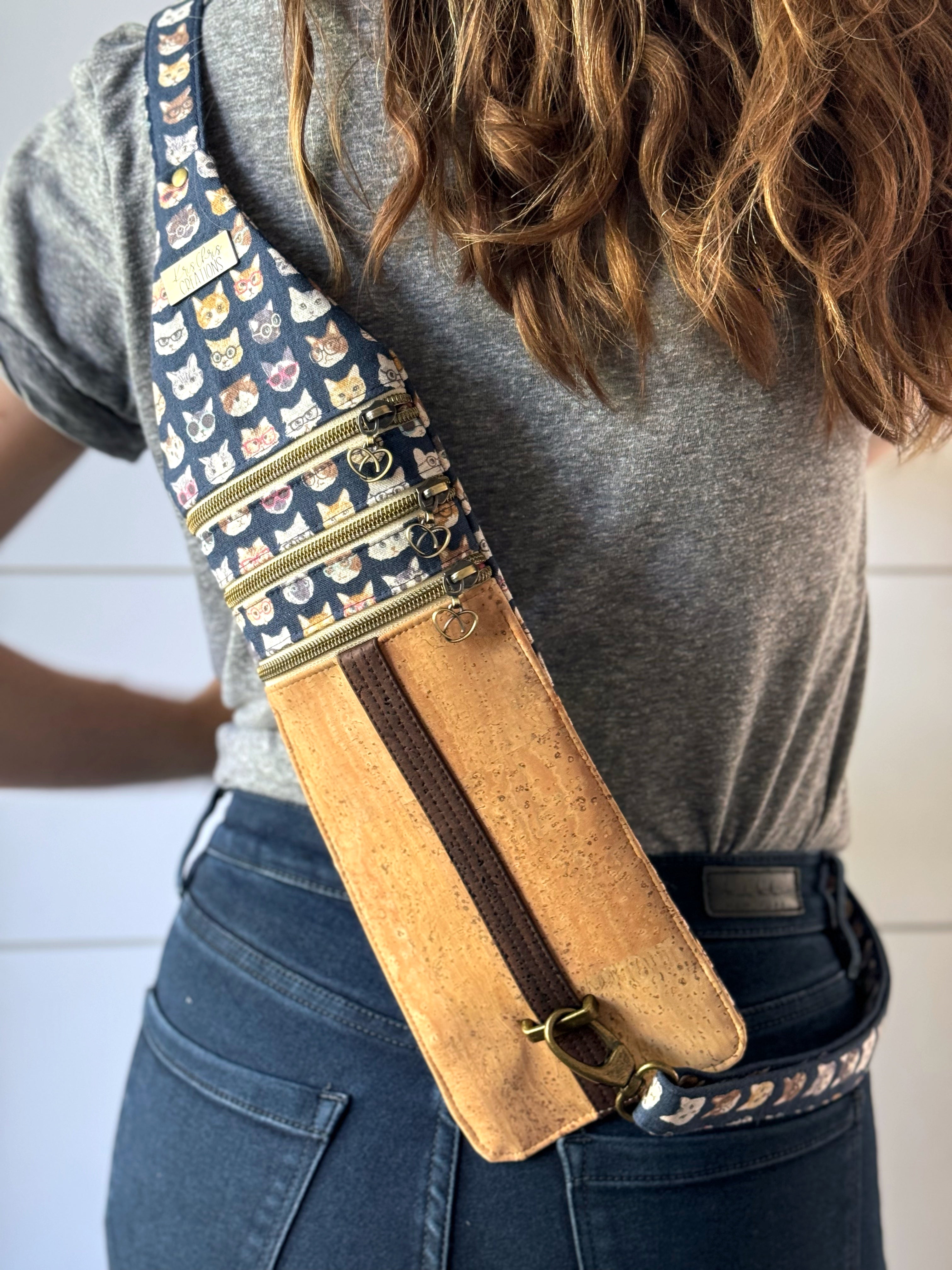 Cat sling bag worn on the back showing 3 dippers and adjustable strap