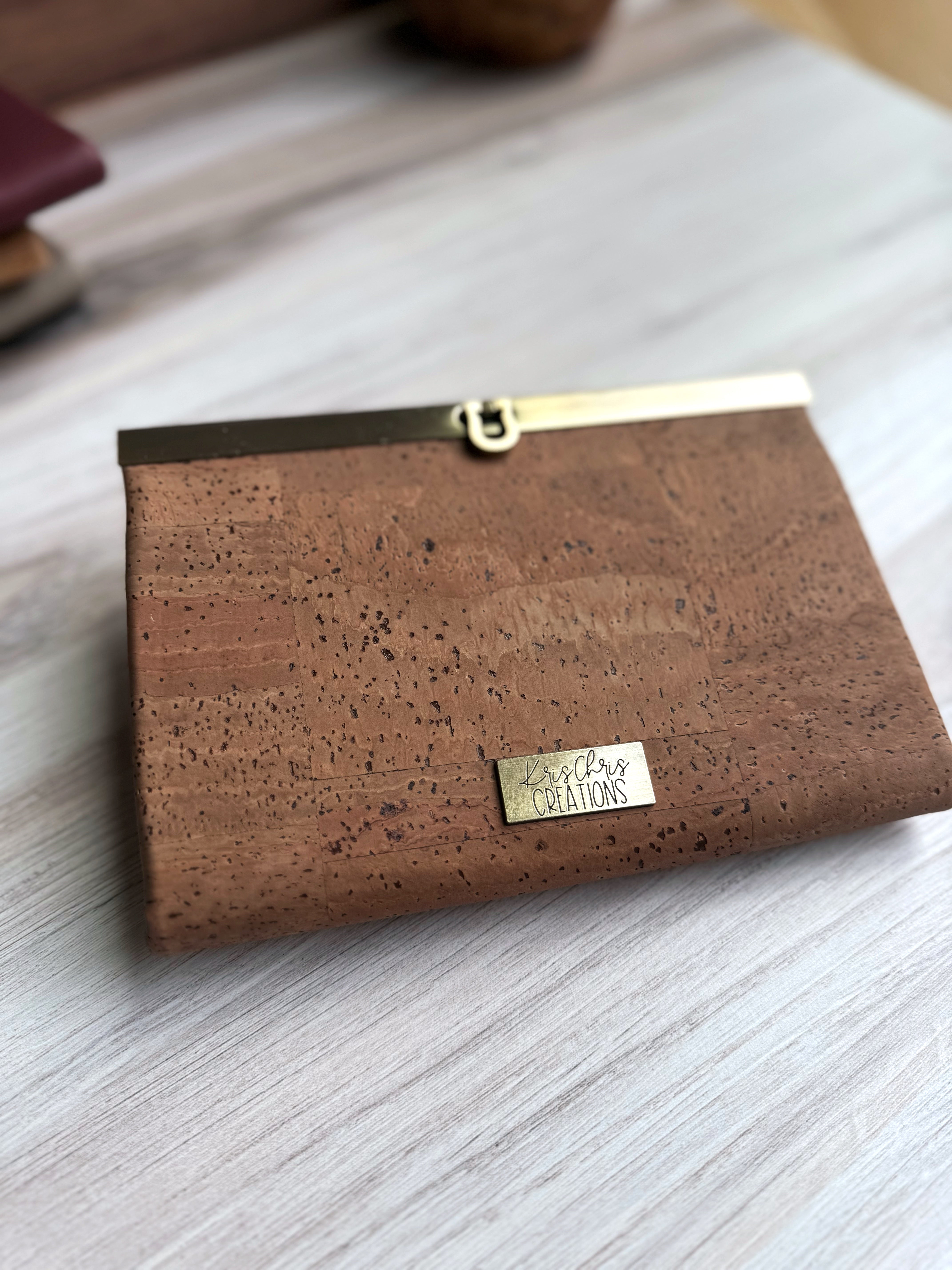 Natural tan cork accordion wallet with antique brass hardware along top edge with KrisChris brass label.