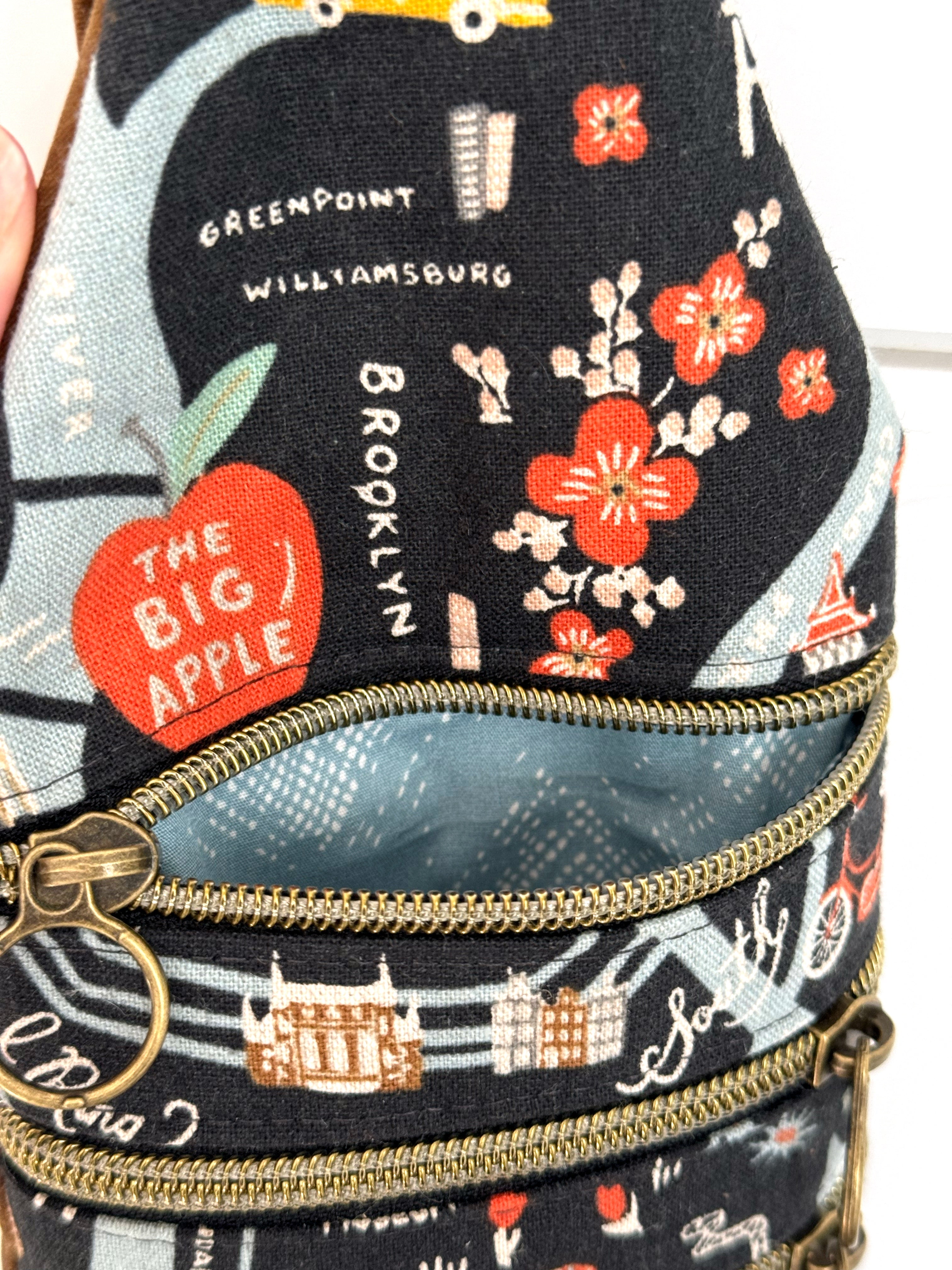 Bag with illustrated New York City map with opened zipper with light blue fabric lining 