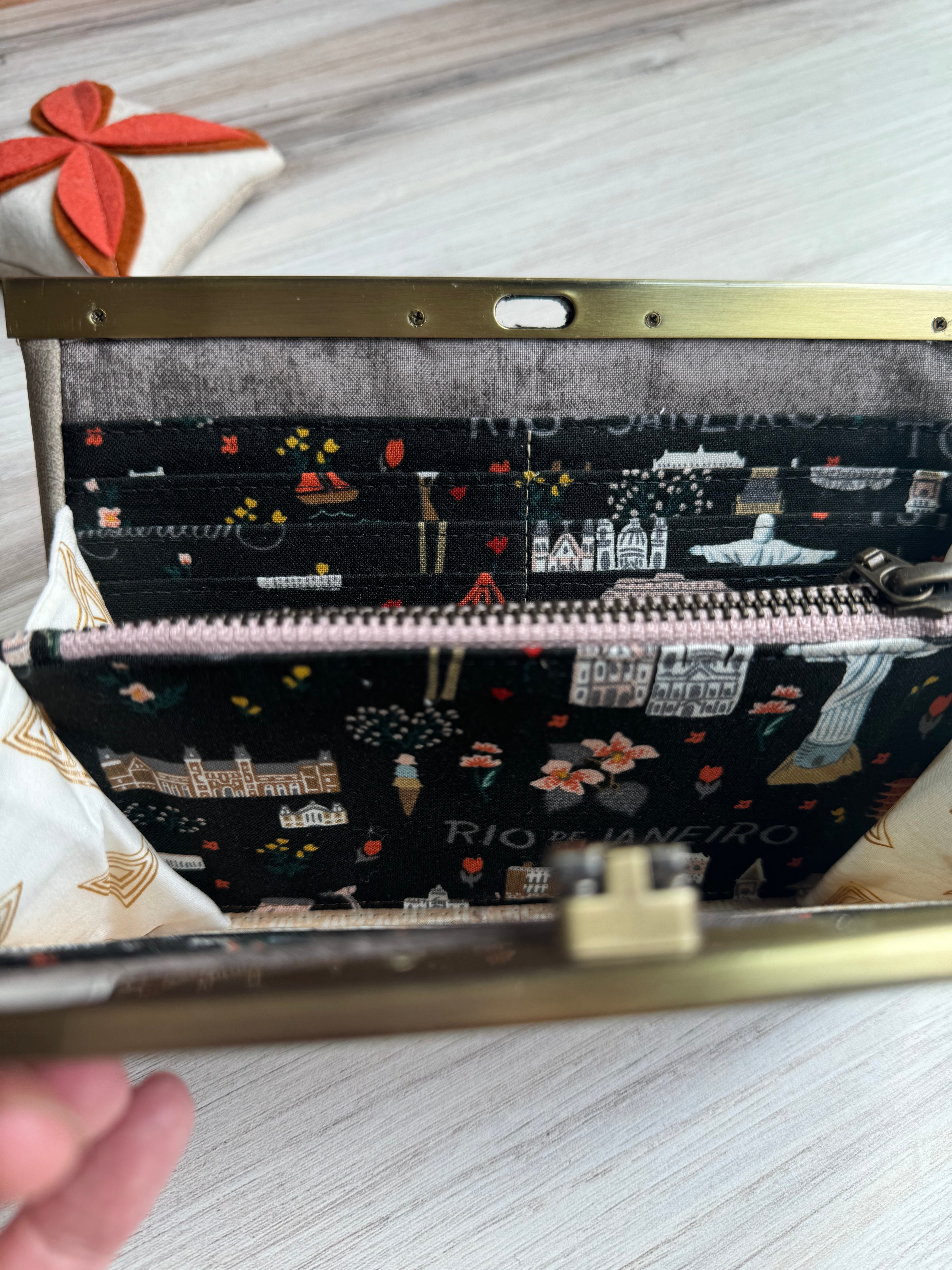 Gray/Tan accordion style wallet opened to show zipper pocket and fun illustrated Rifle Paper fabrics featuring iconic world images