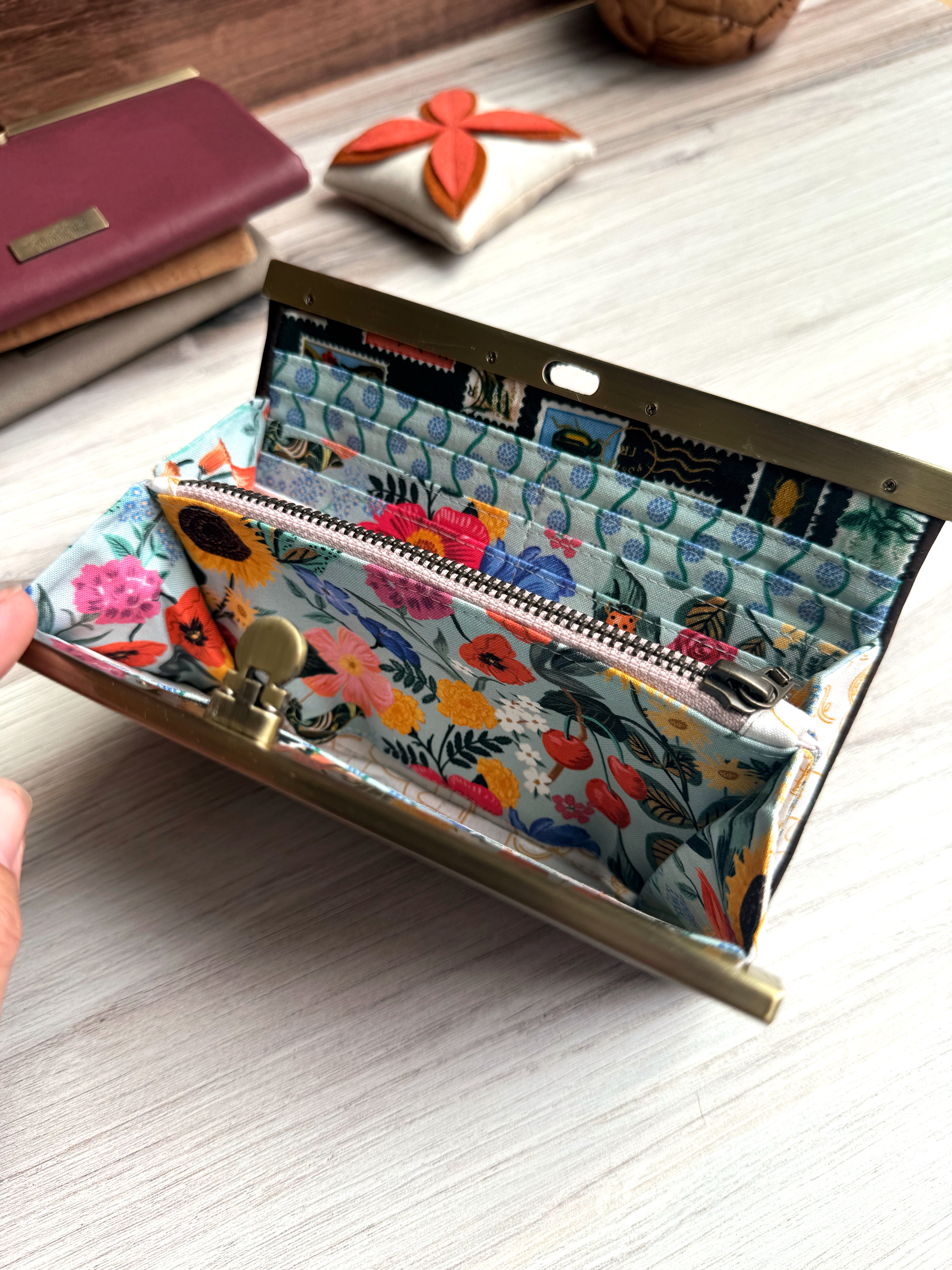 Interior of accordion wallet with Rifle Paper floral fabrics in blue and pink colorful scenes with many card slots and a zippered pouch