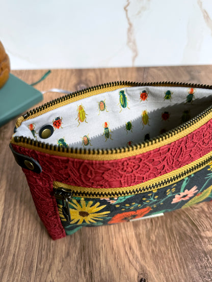 Lining of pouch shows rows of little green, yellow, and red insects that match with floral exterior.