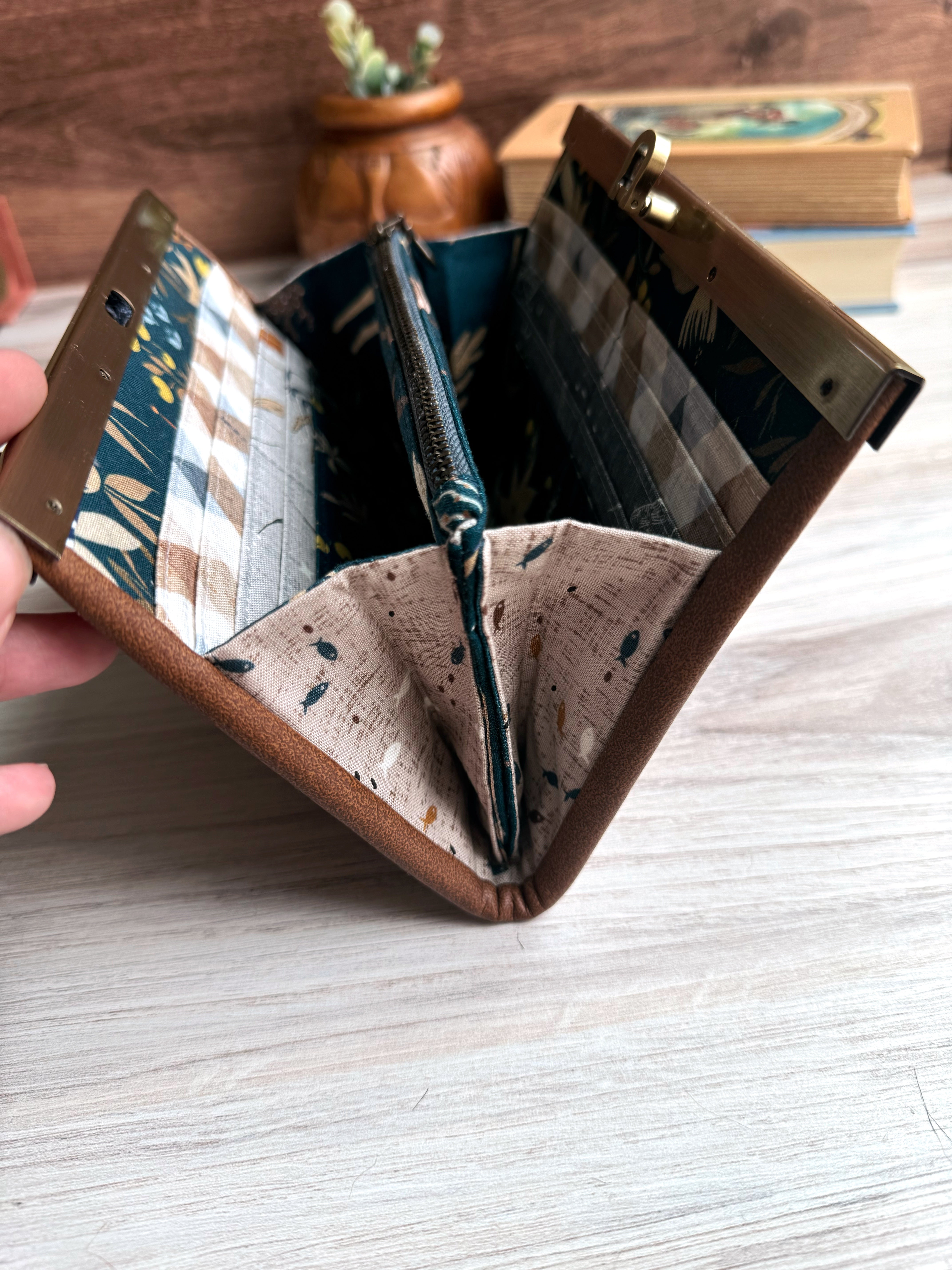 Side view of accordion wallet shows how it opens wide with sweet brown fabric with little fishes all over.