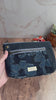 Floral denim waxed canvas navy pouch is shown with interior of zipper pockets showing cat lining and illustrated blue floral lining.